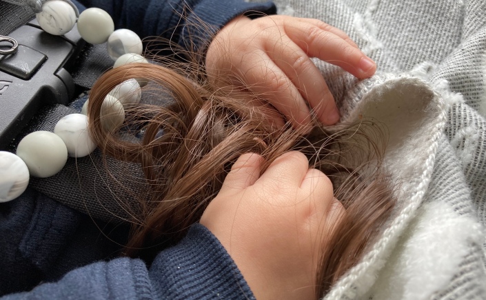 Baby hands holding hair extension